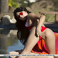Ravishing girl in red bikini with shaved pussy getting naked at the poolside - image 2